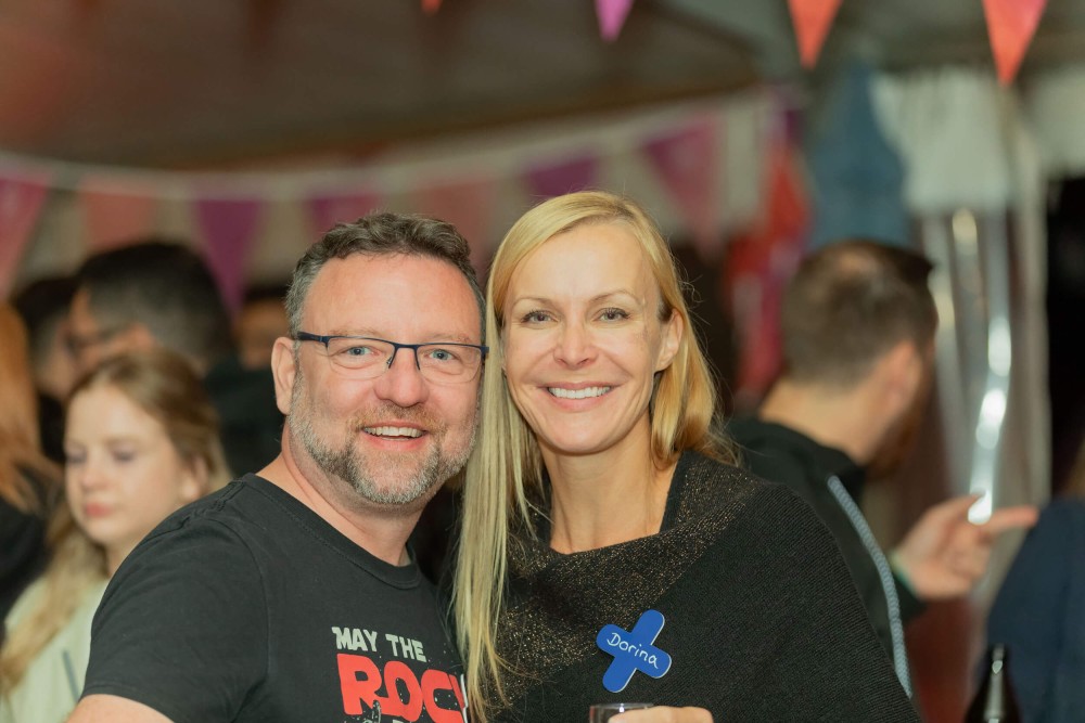 Zwei Unitees auf dem Unite Sommerfest. Im Hintergrund stehen weitere Menschen
